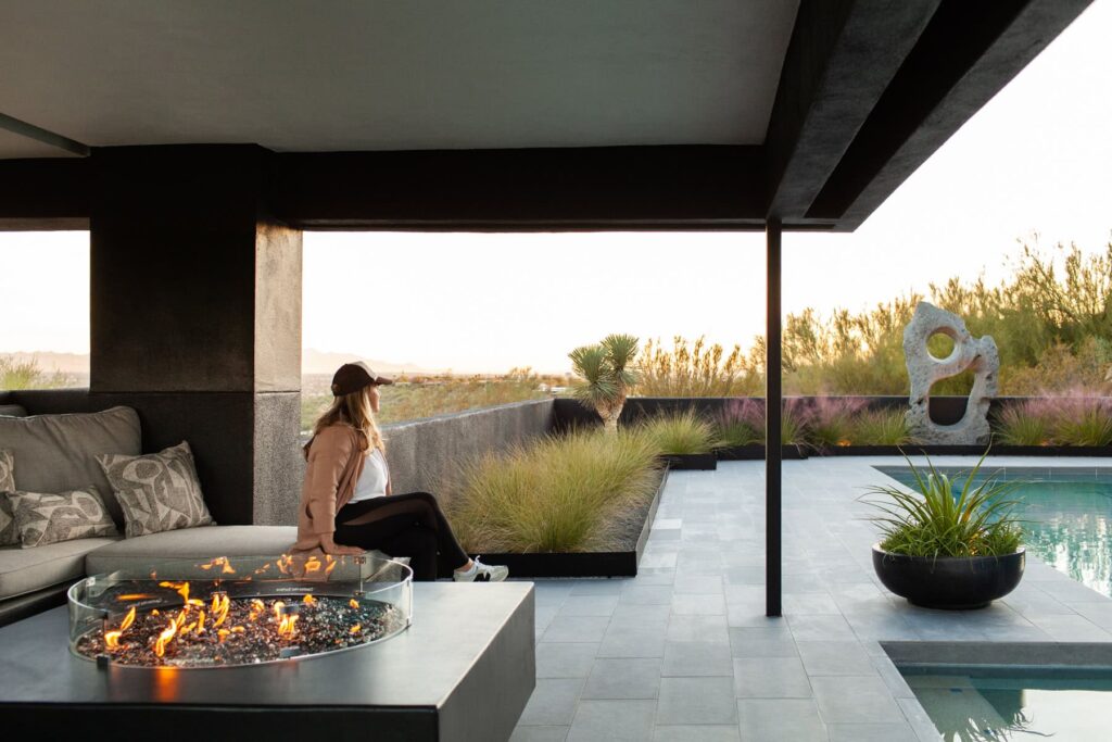 Built-in fire pit glowing at dusk at a Tucson mid-century home, photographed by Fletcher and Co for Box Hill Landscape Design.