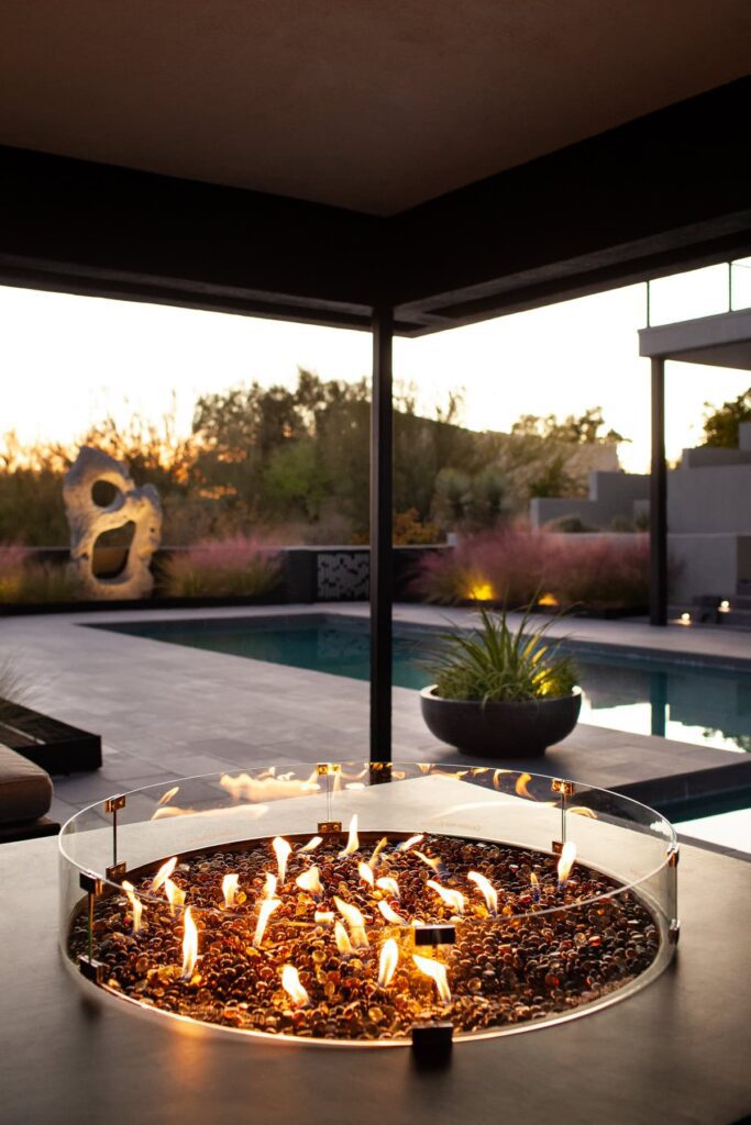 Built-in fire pit glowing at dusk at a Tucson mid-century home, photographed by Fletcher and Co for Box Hill Landscape Design.