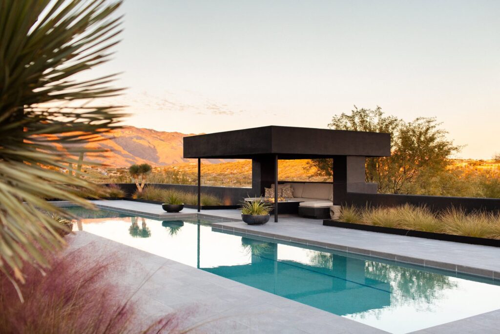 Mass plantings of blooming Muhlenbergia capillaris grasses at a Tucson mid-century home poolside, photographed by Fletcher and Co for Box Hill Landscape Design.