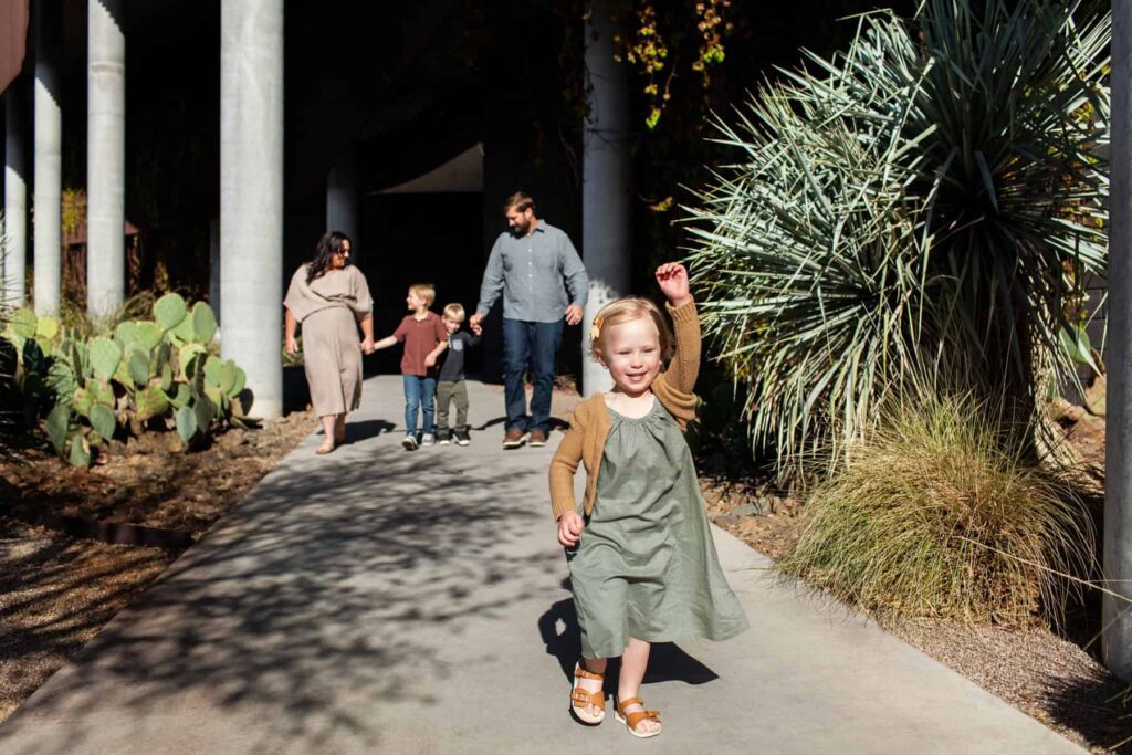 Daughter running ahead of family during their architectural family portrait session