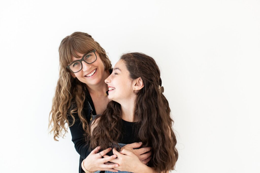 Mother hugging her daughter during a candid studio motherhood photography session in Tucson, Arizona.