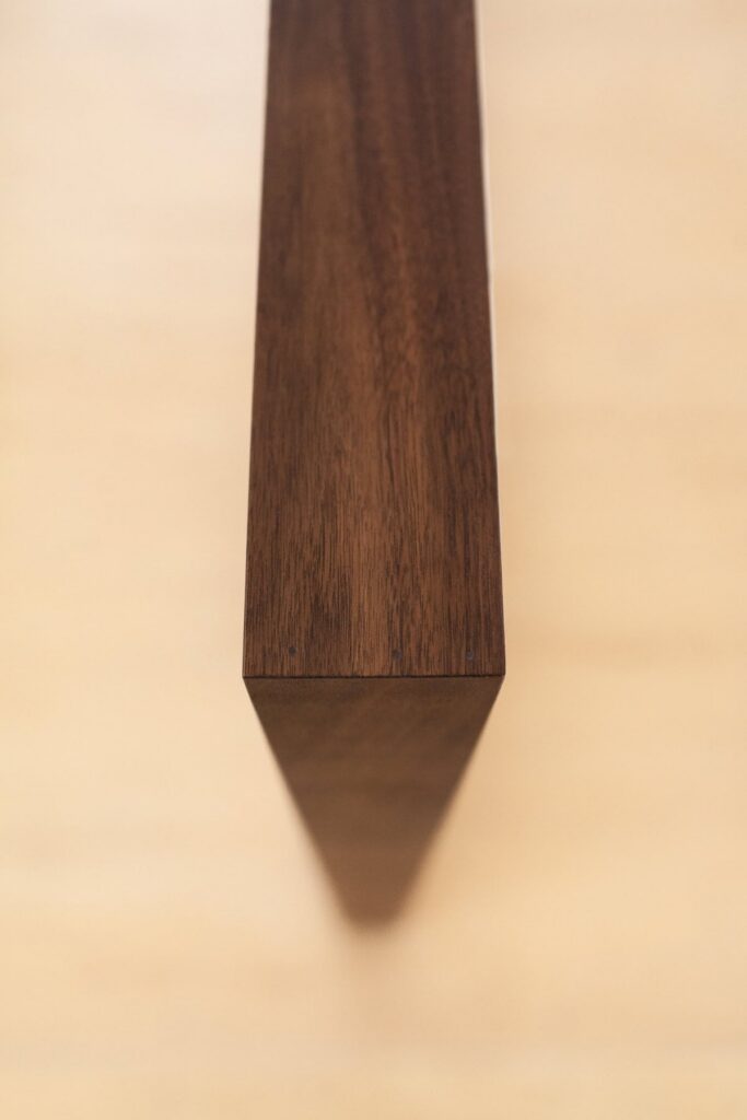 Close-up of custom walnut framed family photograph with museum quality glass reflecting soft studio light