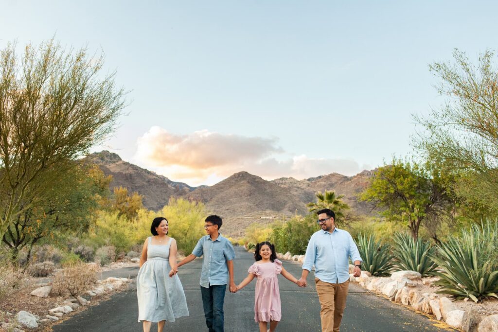 Family walking and laughing together during outdoor photography session in Tucson Arizona desert landscape with candid movement