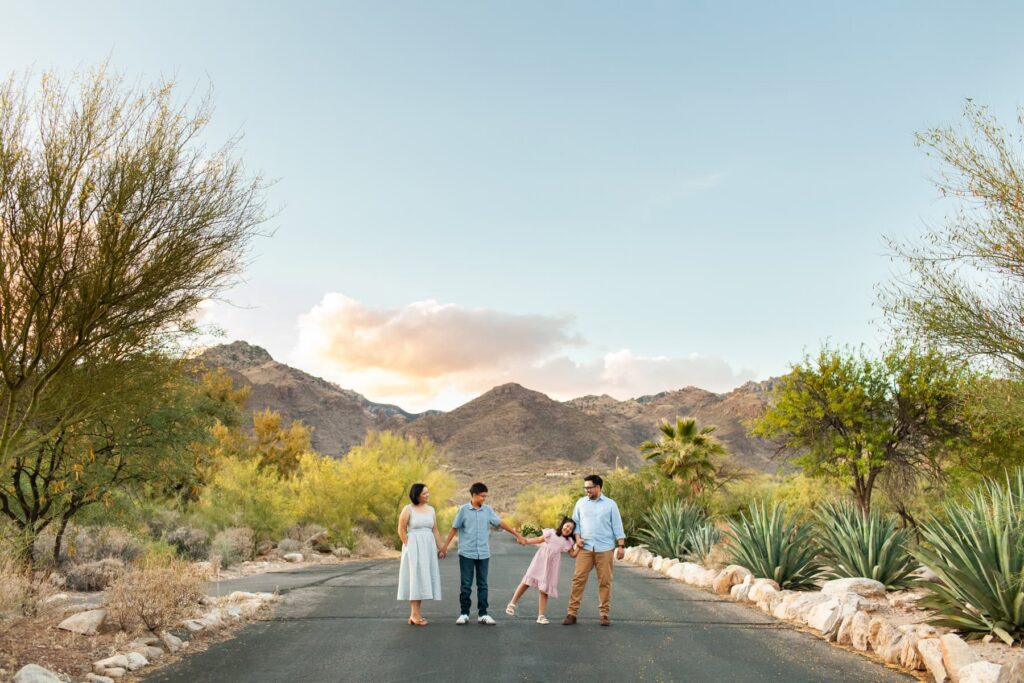 Family walking together during outdoor photography session in Tucson Arizona desert landscape with candid movement