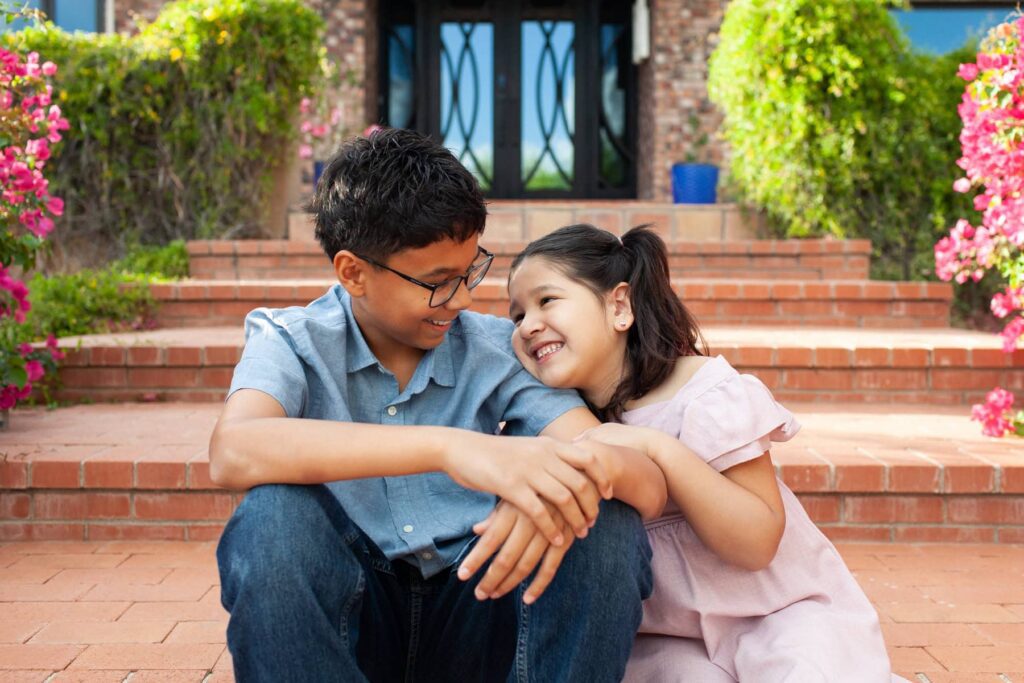 Close emotional moment between two siblings smiling at each other during luxury family photo session in Tucson Arizona