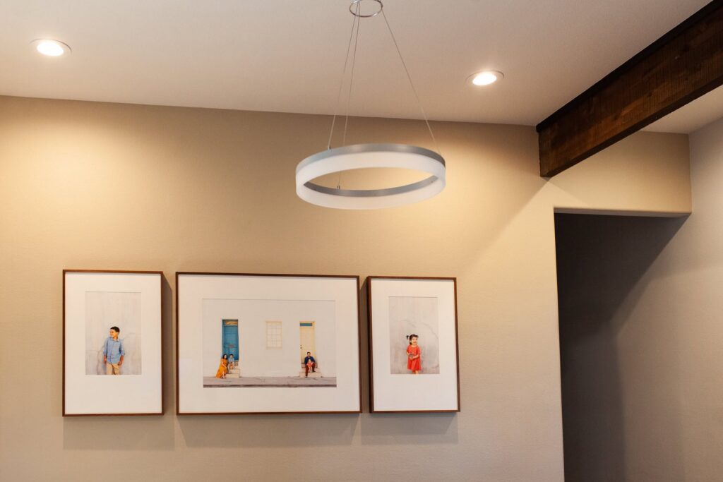 Three framed heirloom family portraits displayed in a dining room in a Tucson home, photography by Fletcher and Co